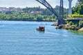 Boat under bridge on Duoro river near Porto city Royalty Free Stock Photo