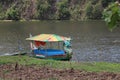 A boat with a unique shape is floating on a clear lake and has a very beautiful view. Jembangan, Kebumen - Indonesia. Good for p