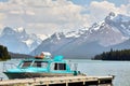 Calm Boat waits in Jasper Lake with Snowy mountains in the background