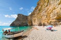 A boat sits on the sandy beach at Chomi Beach on the island of Corfu Greece.