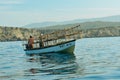 A boat in the water behind cliffs