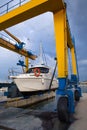 Boat wheel crane elevating motorboat to yearly paint Royalty Free Stock Photo