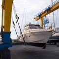 Boat wheel crane elevating motorboat to yearly paint