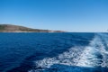 Boat white wake, on blue sea background, view from the ship. Mediterranean sea cruise Royalty Free Stock Photo