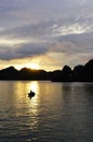 Boat woman against sunset in Halong Bay