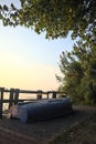 Boat on a wooden pier by the lakeshore next to reeds at sunset