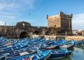 Fishing Boats and fishermen with fortress at the harbor in Essaouira, Morocco Royalty Free Stock Photo