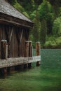 Boathouse sitting in the middle of the water next to wooden beams in Berchtesgaden