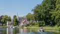 Boating on the river Vecht along the church of Zuilen near Utrecht on summer day Royalty Free Stock Photo