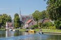 Boating on the river Vecht along the church of Zuilen near Utrecht on summer day Royalty Free Stock Photo