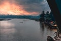 Boatman driving a boat in the river, birds flying in the sky at sunset Royalty Free Stock Photo