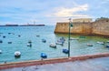 The boats against the stone castles of Cadiz, Spain