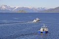 Boats on Alta Fiord with snow capped mountains