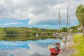 Boats anchored on the shore in the port of Clifden at high tide with reflection in the water