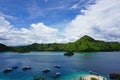 Boats Anchoring In Blue Turquoise Water In Front Of An Island In Komodo National Park In Indonesia
