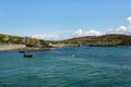 Boats and buoys in the bay, the rocky shoreline with its small harbor, its church on Inishbofin Island