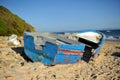 Abandoned small wooden boat -patera- on a beach near Tarifa, coast of Andalusia, Spain.