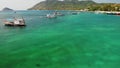 Boats in calm sea in port. Drone view of fishing and dive boats floating on tranquil surface of blue sea in harbor of tropical Royalty Free Stock Photo