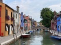 Boats and colorful traditional painted houses in a canal street houses of Burano island, Venice,
