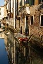 Boats covered from rain parked in the water next to the house in canal of Venice. Royalty Free Stock Photo
