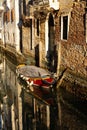 Boats covered from rain parked in the water next to the house in canal of Venice. Royalty Free Stock Photo