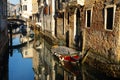 Boats covered from rain parked in the water next to the house in canal of Venice. Royalty Free Stock Photo