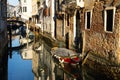 Boats covered from rain parked in the water next to the house in canal of Venice. Royalty Free Stock Photo