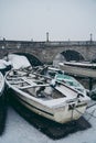 Boats covered in snow and moored on the river in West part of the city