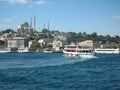 Boats crossiog Bosphorus in the city of Istanbul, Turkey and a mosque with high minarets on the background