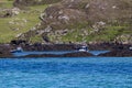 Boats docked in the bay among rocks on Inishbofin Island with a rocky mountain in the background