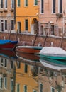 Boats docked on a canal in Venice, Italy and reflection on the water Royalty Free Stock Photo