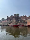 Boats docked near a temple on a riverbank with steps. Varanasi, Uttar Pradesh, India Royalty Free Stock Photo