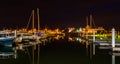 Boats and docks reflecting in the water at night, at a marina on Royalty Free Stock Photo