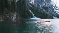 Boats floating on turquoise water alpine lake Lago di Braies in Dolomiti mountains, Belluno, Veneto, Italy with