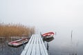 Boats at a frosty wooden jetty in a misty lake in Sweden. Royalty Free Stock Photo