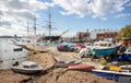 Boats grounded on the shore line in front of HMS Warrior, Britain`s first iron-hulled, armoured battleship, moored at Portsmouth D