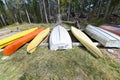 Boats kayaks and canoes lying on tree trunks