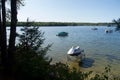 Boats on lake water with evergreen trees