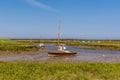 Boats moored in an estuary of Brancaster Bay near Burnham, Norfolk, UK