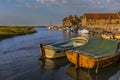 Boats moored on the River Glaven bask in the evening sunset at Blakeney, Norfolk, UK Royalty Free Stock Photo