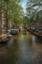 Boats moored at side of canal and brick buildings in Amsterdam Royalty Free Stock Photo