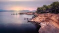 Boats moored beside stone jetty at sunset, overlooked by beautiful rocks and trees, with calm sea, Betlem, Mallorca, Spain Royalty Free Stock Photo