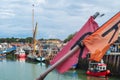 Boats moored in Whitstable harbour with fishing marking flags in the foreground