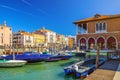 Boats moored in wooden pier dock of Grand Canal waterway in Venice