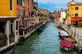 Boats on narrow canal along old colorful houses in Venice, Italy. Royalty Free Stock Photo