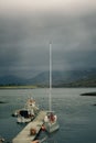 Boats near a dock floating in a tranquil body of water.