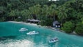 Boats Near Ocean Beach With Huts Among Palm Trees In Kaimana Island, Raja Ampat. Stunning View From Drone On Water Transport Royalty Free Stock Photo