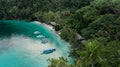 Boats Near Ocean Beach With Huts Among Palm Trees In Kaimana Island, Raja Ampat. Stunning View From Drone On Water Transport Royalty Free Stock Photo