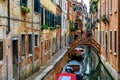 Boats along buildings on a canal in Venice Italy