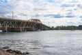 Boats passing under an old road bridge on a cloudy autumn day